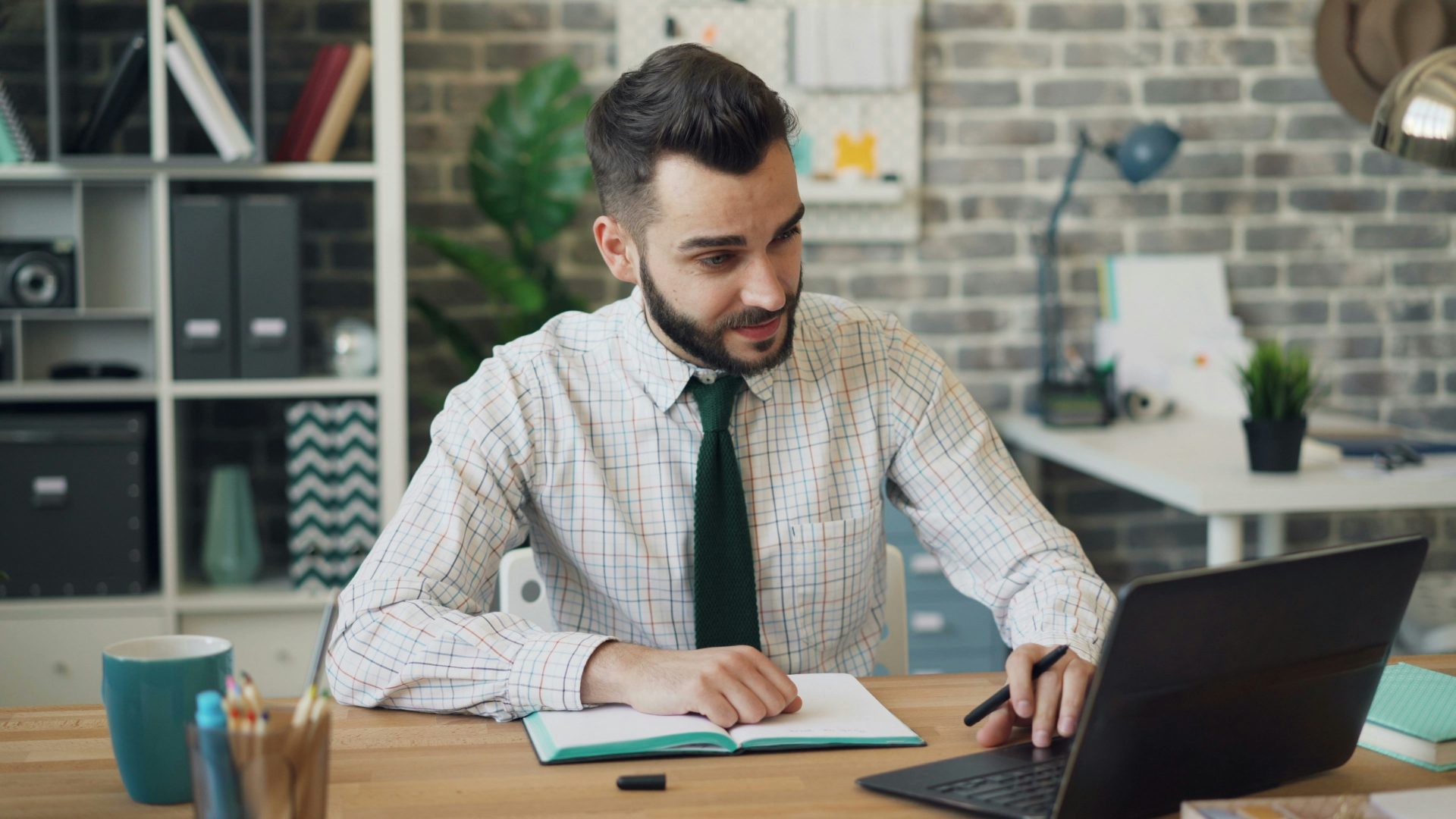 a man sitting at a desk working on a laptop